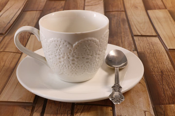 Obraz na płótnie Canvas white cup on a saucer on a wooden background