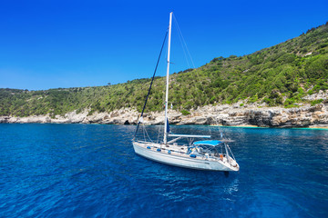 Fototapeta na wymiar Beautiful bay with sailing boat, Antipaxos island, Greece