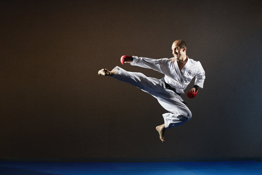 A sportsman in a jump trains a kick to the side