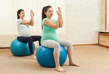 Obraz premium Beautiful pregnant women doing yoga on the balls
