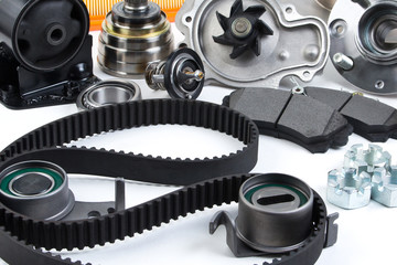 Auto parts background. Hub, pump, brake pads, filter, timing belt, rollers, constant velocity joints, thermostat and other on white background. Set of spare parts for repair