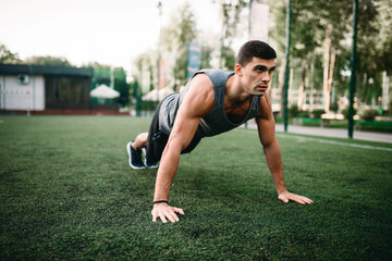 Athlete doing push-up exercise on outdoor workout