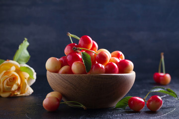 Fresh cherries in wooden bowl on black background. Fresh ripe red sweet cherries. horizontal, room for text