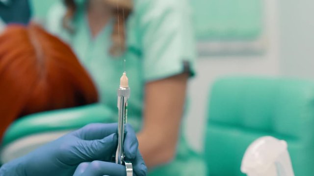 dentist prepares syringe for injection of anesthesia, close up