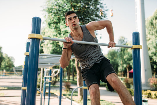 Man doing exercise on horizontal bar outdoor