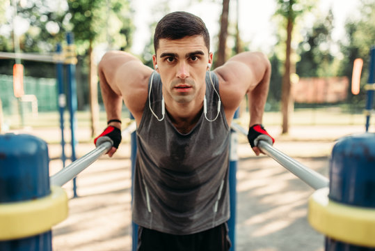 Man doing exercise on parallel bars, front view