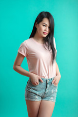 Asian woman smiling with black long hair, black eyes on pastel blue background cute nice girl face,...