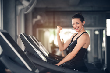 Sport Caucasian Woman on Treadmill Showing Her Muscle with Happy to Workout and Exercises in Gym - Lifestyle Concept