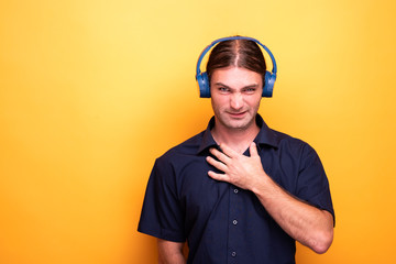 Man wearing headphones resting his hand to its chest