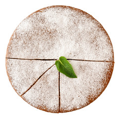 Whole cut sponge cake with icing sugar isolated on white from above. Mint leaf garnish.