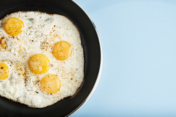 Breakfast Food Fried one egg in a frying pan isoalted on blue background copy space for text
