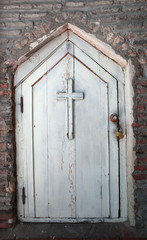 Wooden white front door with a cross to the monastery room