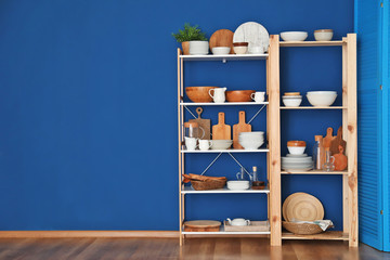 Kitchen shelving with dishes on blue wall background