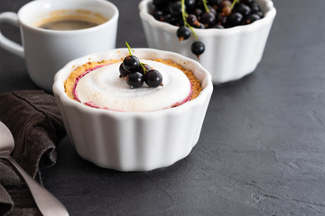 Pie with fruit and berry filling and meringue with a cup of coffee on a black background.