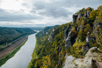 Aerial scenic Autumn Landscape of Elbe river and beautiful colorful forest. Saxon Switzerland National Park in Germany