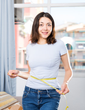 Young girl standing with measuring tape around her waist