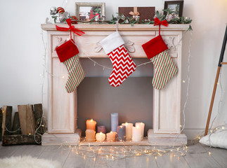 Decorative fireplace with beautiful decor and Christmas stockings indoors