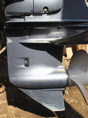 Lower unit outboard motor on the transom of the boatv – gear case with hydro stabilizer and white aluminium propeller 