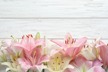 Flat lay composition with beautiful blooming lily flowers on wooden background - obrazy, fototapety, plakaty