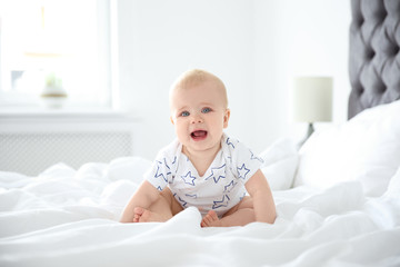 Cute little baby crawling on bed at home