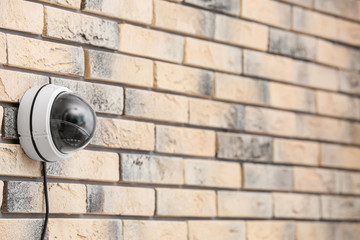 Modern security CCTV camera on brick wall