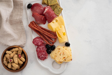 Typical italian antipasto,with prosciutto, ham, cheese and olives on white background. Top view with copy space.