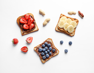 Tasty toast bread with banana, strawberry and blueberry on white background