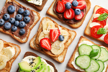 Tasty toast bread with fruits, berries and vegetables on light background, closeup