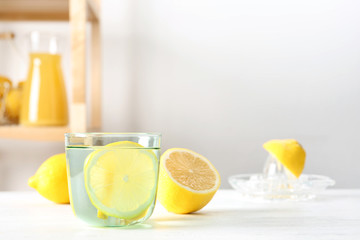 Glass of water with lemon slice on table