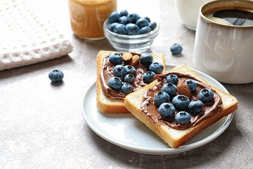 Toast bread with blueberries and chocolate paste on table