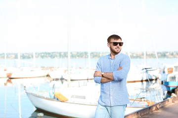 Naklejka premium Young hipster man in jeans on pier