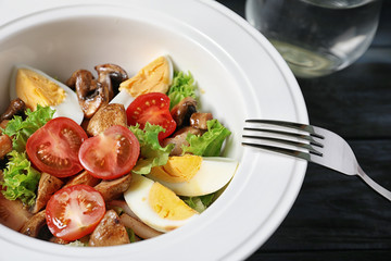 Plate with delicious fresh salad on table, closeup
