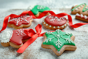 Fototapeta na wymiar Tasty decorated Christmas cookies on wooden board, closeup