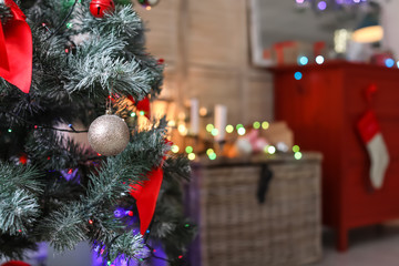 Christmas tree with decorations in stylish interior