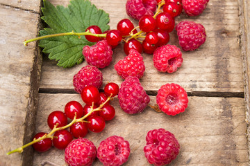 Berries of currants and raspberries on an old board. Red berries on an old board.