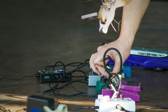 Guitarist Tunes The Guitar. The Pedal Board At A Gig. Guitar Effects