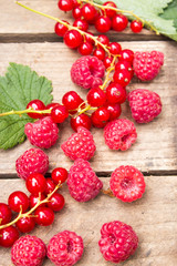 Berries of currants and raspberries on an old board. Red berries on an old board.