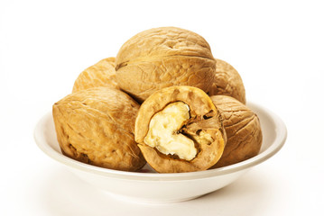Walnuts in white bowl isolated on white background