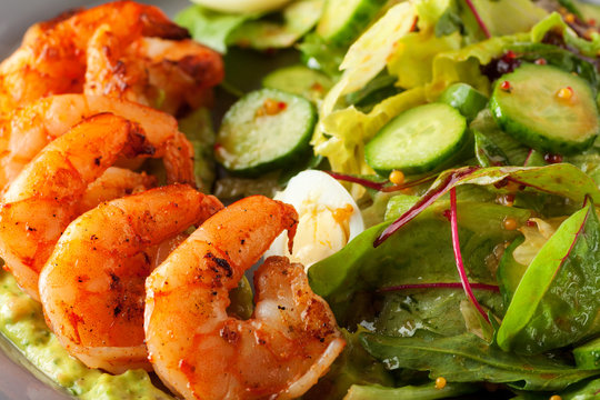 Delicious grilled shrimps served with salad with green vegetables - lettuce, cucumber