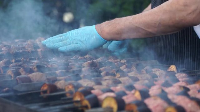 Restaurant buffet outdoors. The chief grills meat with vegetables and fish. Reck focus.