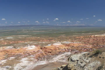 Aerial view on multicolored red, orange and yellow striped hills under the bright blue sky in...