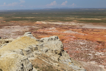 Aerial view on multicolored red, orange and yellow striped hills under the bright blue sky in Kiin-Kerysh (Valley of Spirits) Eastern Kazakhstan
