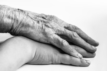 The hand of a mature man covers the child's hand