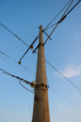 high round concrete pillar with wires on blue sky background