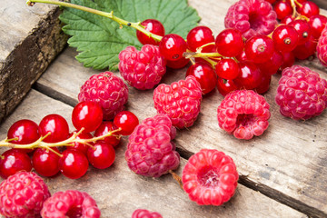 Berries of currants and raspberries on an old board. Red berries on an old board.