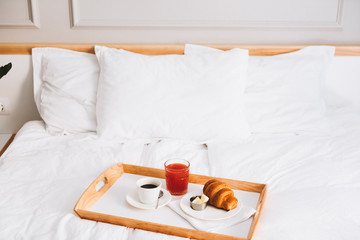Ideal breakfast in bed. Coffee, grapefruit juice and croissant with butter. Perfect early morning...
