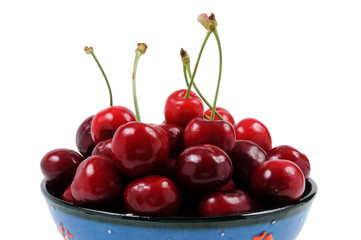 Ripe cherry close-up in a bowl on a white background. Front view.