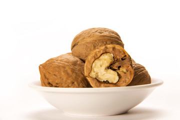 Walnuts in white bowl isolated on white background