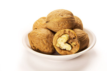 Walnuts in white bowl isolated on white background
