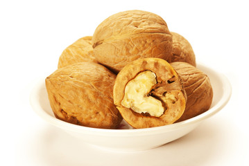 Walnuts in white bowl isolated on white background